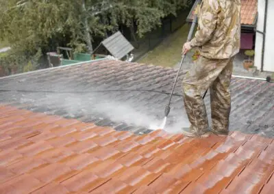 Nettoyage des tuiles d'une toiture incrustées par les mousses et la pollution atmosphérique